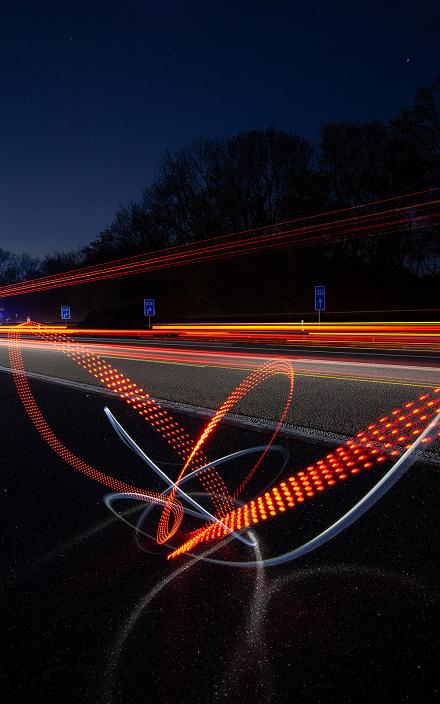 Road at night with red and white light trails