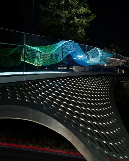 Bridge with a green and blue light installation at night