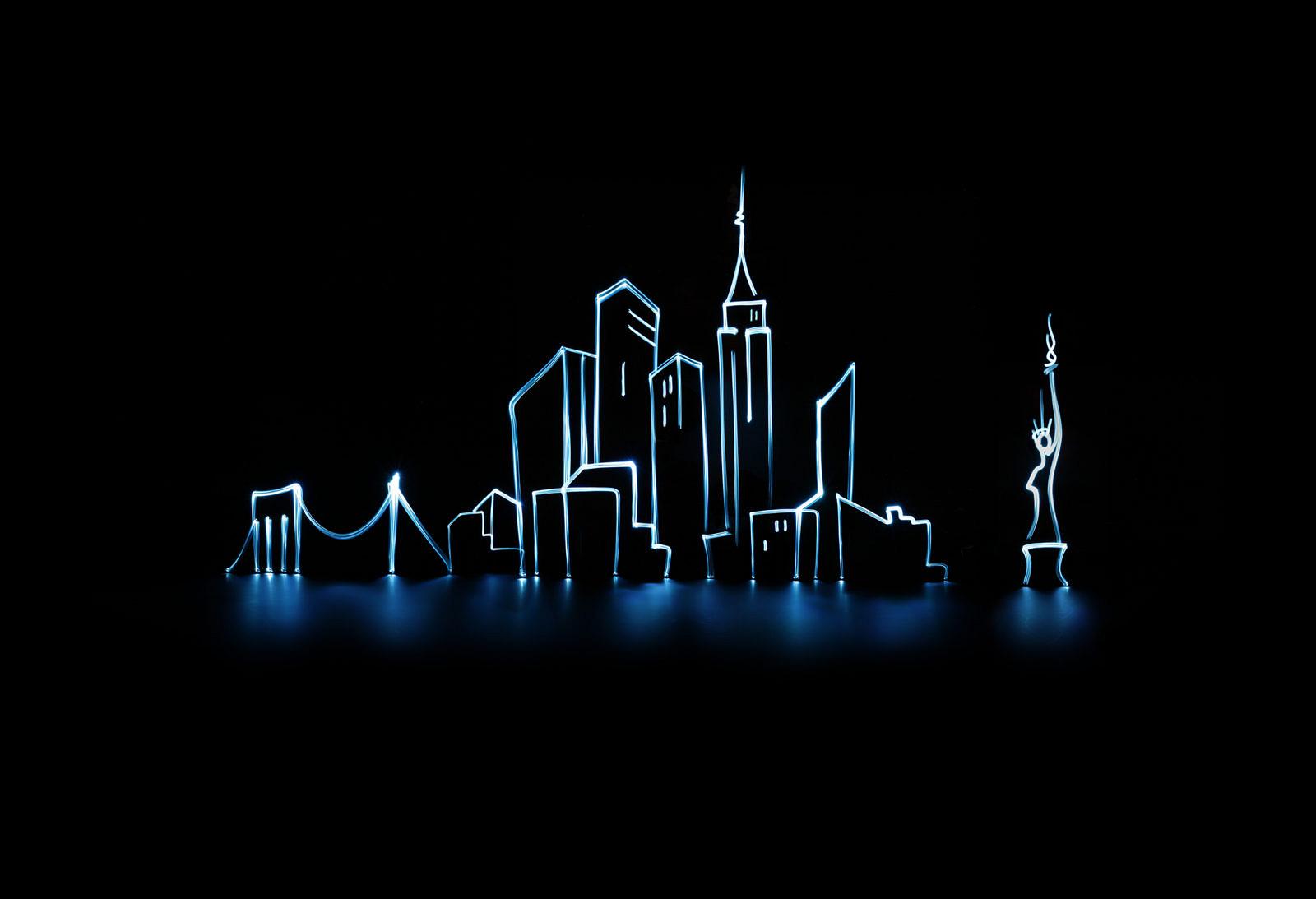 Mit Licht gezeichnete Skyline mit Brücke und Hochhäusern vor schwarzem Hintergrund
