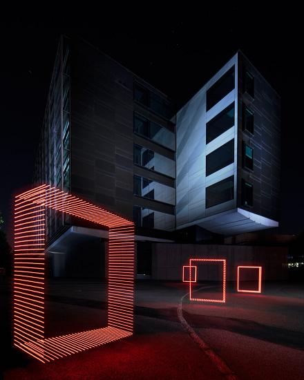 Office building at night with a red light drawing of geometric frames