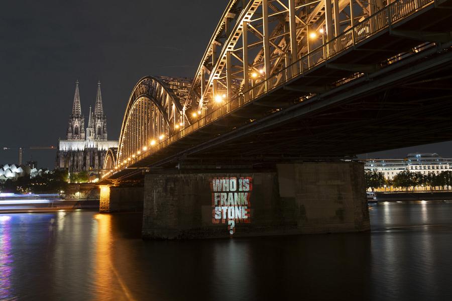 Hohenzollernbrücke in Köln bei Nacht, mit Lichtspiel und der Frage Wer ist Frank Stone?.
